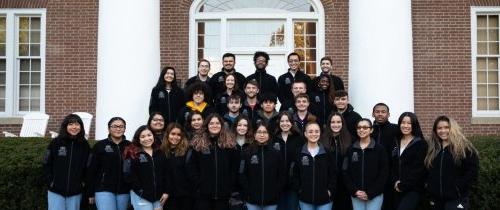 Large group of students standing in front of Old Centre with matching fleece jackets with Grissom student logo